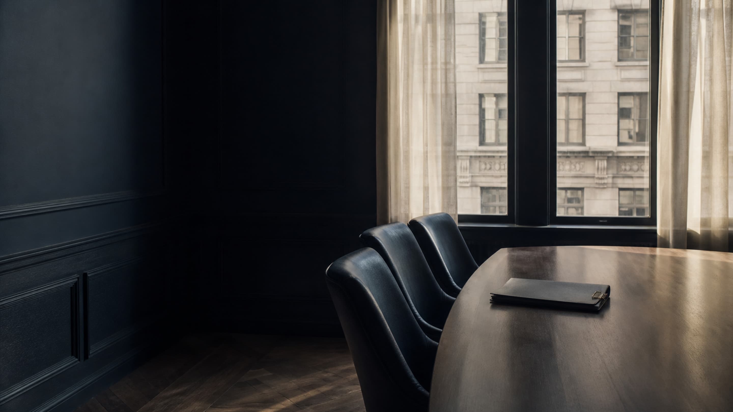 A quiet prewar Manhattan boardroom with a walnut table, navy leather chairs, and a closed board packet